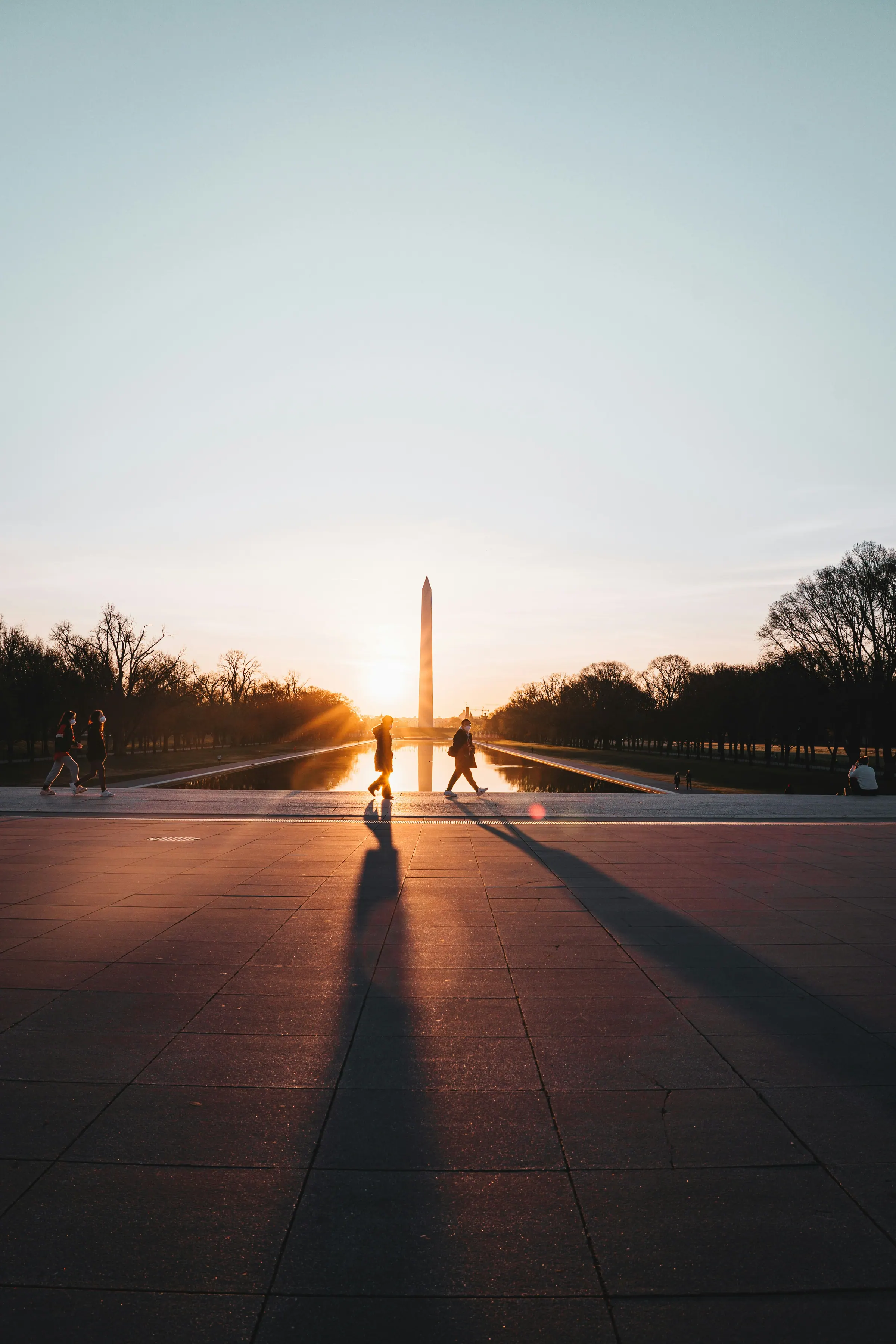 Visitors walking beside the Reflecting Pool toward the Washington Monument